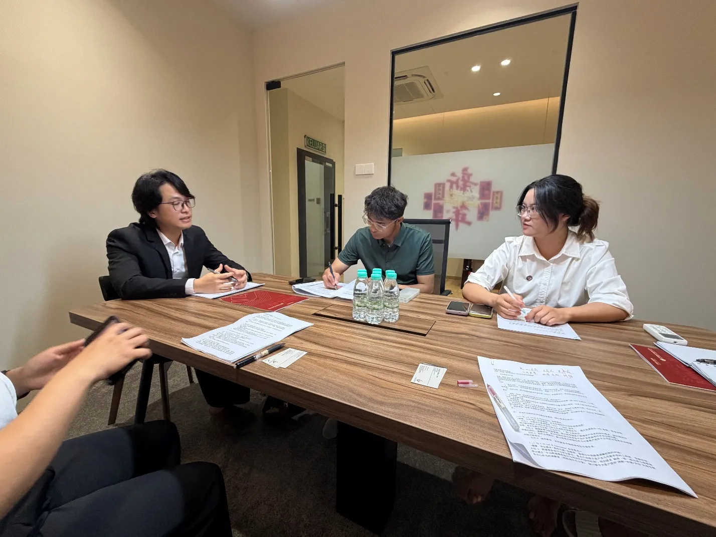 Representatives of both firms reviewing documents together during the exchange session at the L.X. Chiah & Associates office