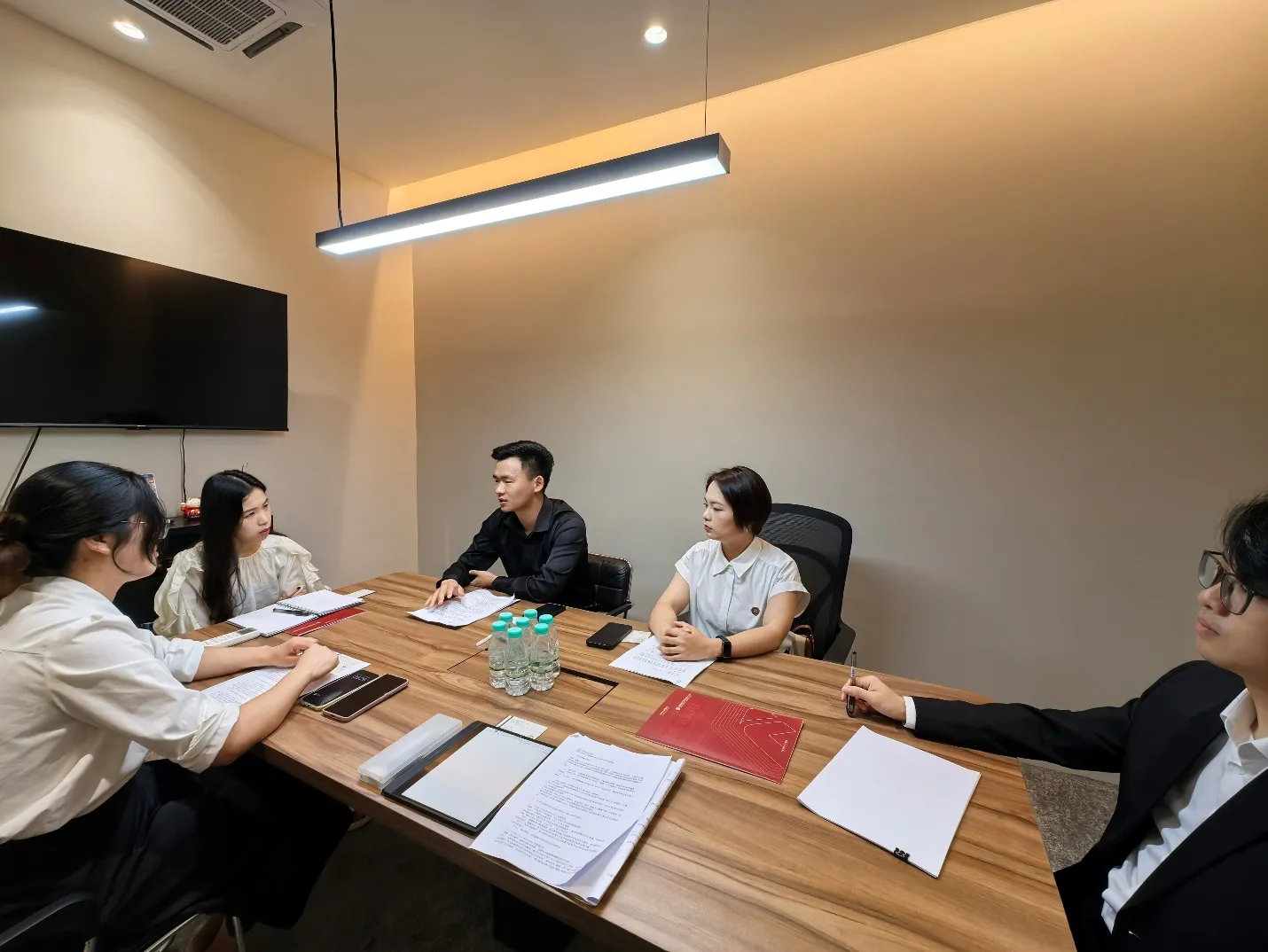Legal professionals from both firms seated around the conference table during the exchange session